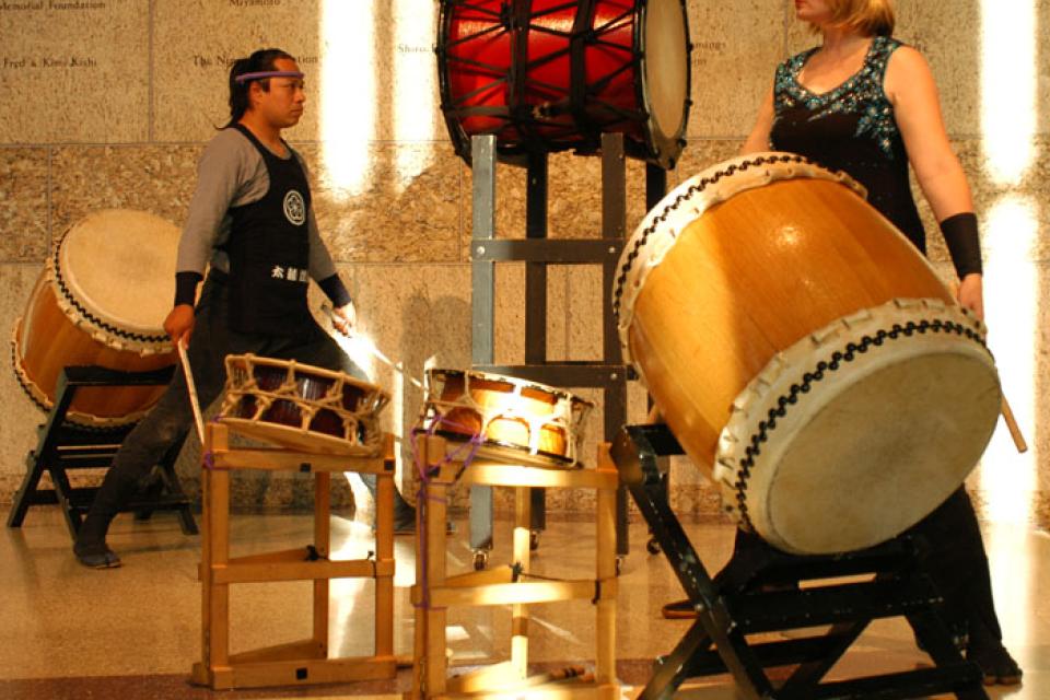 David Gonzalez and Heidi Varian poised in front of their drums